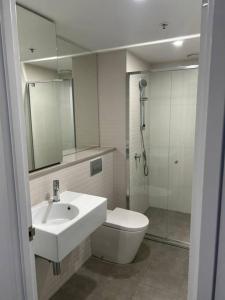 a bathroom with a sink and a toilet and a mirror at 112 at Plush Midnight in Canberra +12 photos