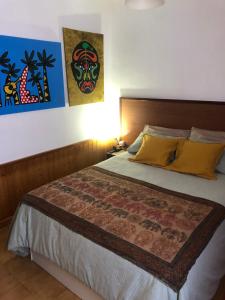 a bedroom with a large bed with yellow pillows at Nankurunaisa in Vigo
