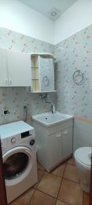 a bathroom with a washing machine and a toilet at Ruggero House in Cefalù