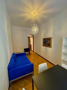 Una sala de estar con un sofá azul y una mesa. en La Dolce Vita, en Pisa