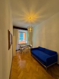 Una sala de estar con un sofá azul y una mesa. en La Dolce Vita, en Pisa