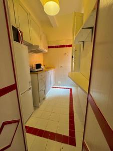 Una pequeña cocina con gabinetes blancos y piso rojo y blanco. en La Dolce Vita, en Pisa