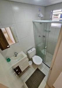 a bathroom with a toilet and a glass shower at Apartamento 3 quartos! in Joinville +15 photos