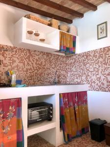 una cucina con lavandino e forno a microonde di Tenuta di Corsano a Monteroni dʼArbia