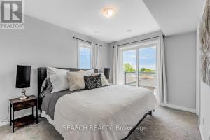 a bedroom with a bed and a large window at Cozy 3 story Townhouse! in Niagara Falls