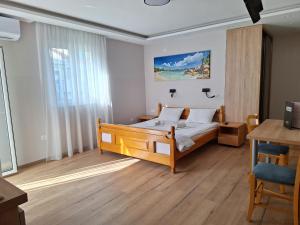 a bedroom with a bed and a table and a desk at Apartments Srzentic in Petrovac na Moru +154 photos