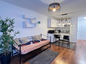 Una sala de estar con una cama y una cocina. en W&L Paris Apartment 68m - 3 min Métro 4 - A Paris Centre 15min, en Bagneux