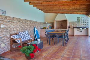 a patio with a table and chairs and a brick wall at Casa con piscina, vistas y cerca de las playas in Vigo