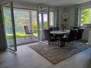 a dining room with a table and chairs and a patio at Ferienwohnung Witting in Wenns