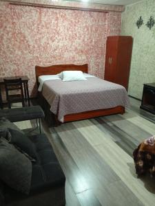 1 dormitorio con 1 cama y 1 sofá en La Perla Cuencana Hostal en Cuenca