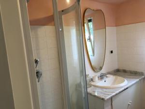 a bathroom with a sink and a mirror at Casetta in giardino con piscina in Luino +9 photos