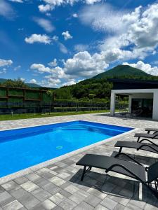 a swimming pool with two chairs and a picnic table at Unavis Residence in Bihać