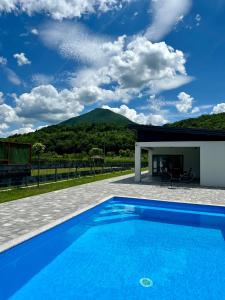 a swimming pool in front of a house at Unavis Residence in Bihać
