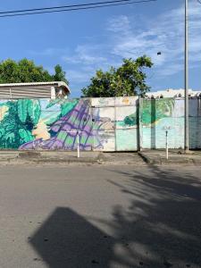 eine Wand mit Graffiti neben einer Straße in der Unterkunft Studio vue sur mer Fort D'épée in Le Gosier
