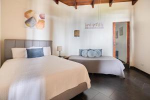 a bedroom with two beds in a room at Perla de la Playa Beachfront Hotel in Tamarindo +80 photos