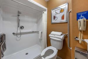a bathroom with a shower and a toilet and a phone at Best Western Plus Stovall's Inn in Anaheim +45 photos