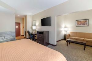 a hotel room with a bed a couch and a television at Best Western Carowinds in Fort Mill