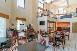 a restaurant with tables and chairs and a kitchen at Best Western Carowinds in Fort Mill