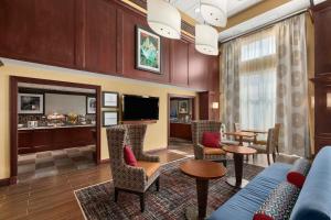 ein Hotelzimmer mit einem Sofa, Stühlen und einem TV in der Unterkunft Hampton Inn & Suites Cleveland-Beachwood in Beachwood