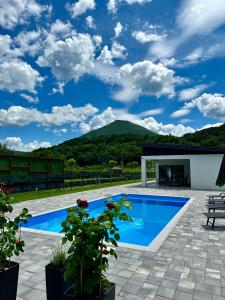 a patio with a blue swimming pool with mountains in the background at Unavis Residence in Bihać