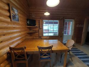 ein Esszimmer mit einem Holztisch und Stühlen in der Unterkunft Pankkotupa 16-B in Punkaharju