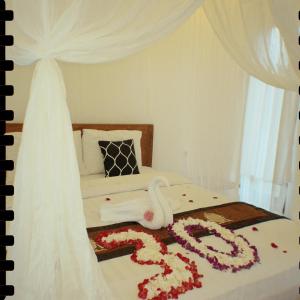 a bedroom with a bed with flowers on it at Papahan Bali in Sidemen