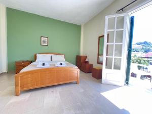 a bedroom with a bed and a door to a balcony at Alexandra's Apartments in Sidari