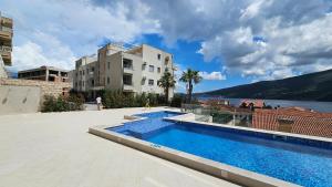 赫尔采格诺维Bella Vista Residence D7的一座大楼和一座大楼前的游泳池