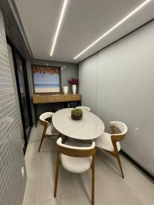 a dining room with a white table and chairs at Flat Beira-mar - Pepper Village in Salvador