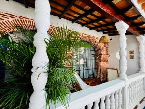 a porch with a white railing and plants at Los Patios Hostel in Cartagena de Indias