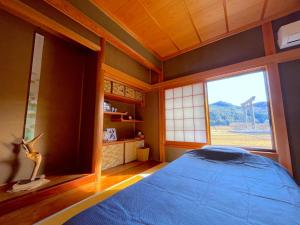 Villa KUMANO في هونغو: غرفة نوم بسرير ازرق ونافذة