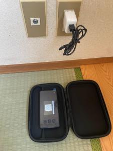 a cell phone in a black case on the floor at メゾンドリバージュ205 in Tokyo