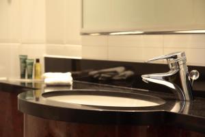 a bathroom counter with a sink and a mirror at Glasgow Grosvenor Hotel in Glasgow