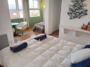 1 dormitorio con 1 cama blanca grande en una habitación en Hotel Montealegre, en Valparaíso