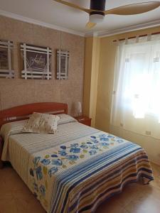 sypialnia z łóżkiem z niebieskim i żółtym kocem w obiekcie Joyitas Gandía Beach w mieście Playa de Gandia