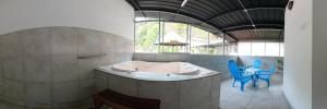 un bagno con una vasca e alcune sedie blu di Hostal & Spa Casa Real a Baños
