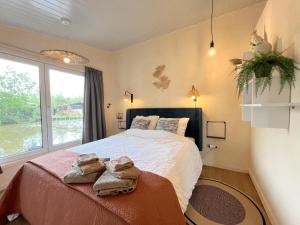 una camera da letto con un grande letto con asciugamani di Charlies Chalet a Geel
