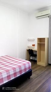 una camera con letto, scrivania e di HOMESTAY KIKA SYARIAH PURWOKERTO a Purwokerto