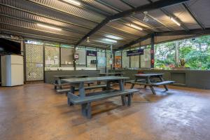 a cafeteria with picnic tables and a kitchen at Tasman Holiday Parks - Cairns Cool Waters in Cairns