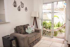 a living room with a couch and a window at Apartamento Cactus no Dallas Park in Campina Grande