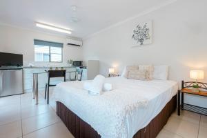 a bedroom with a large bed and a kitchen at Tasman Holiday Parks - Cairns Cool Waters in Cairns