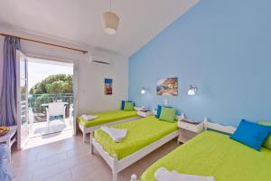 a bedroom with two beds and a balcony at Aelia Studios in Koukounaries