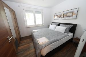 um quarto com uma cama e uma janela em Luksuzni stan u Starom Gradu em Saraievo