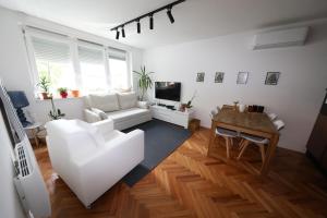 uma sala de estar com um sofá branco e uma mesa em Luksuzni stan u Starom Gradu em Saraievo
