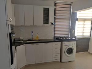 a kitchen with white cabinets and a washing machine at נוף ים אילת in Eilat