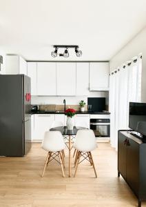a kitchen with white cabinets and a table and chairs at Paris with AC near Eiffel Tower in Paris