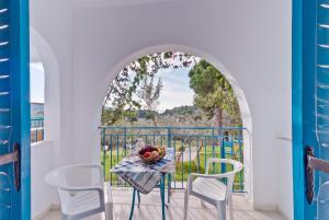 a table with a bowl of fruit on a balcony at Aelia Studios in Koukounaries
