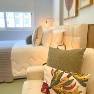 ein Schlafzimmer mit einem Bett und einem Sofa mit einem Kissen in der Unterkunft Loft luxuoso na Serra - Granja Brasil Resort itaipava - Petrópolis in Petrópolis