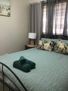 - Toalla verde en la cama de un dormitorio en Hideaway on King, en Urangan