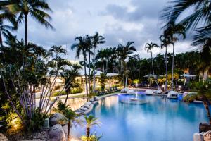 einen Pool in einem Resort mit Palmen in der Unterkunft Reef Resort Villas Port Douglas in Port Douglas